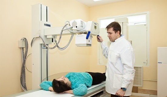 Рентген-лаборант готовит пациентку к обследованию