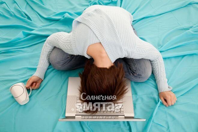 Уставшая девушка лежит на ноутбуке, фото