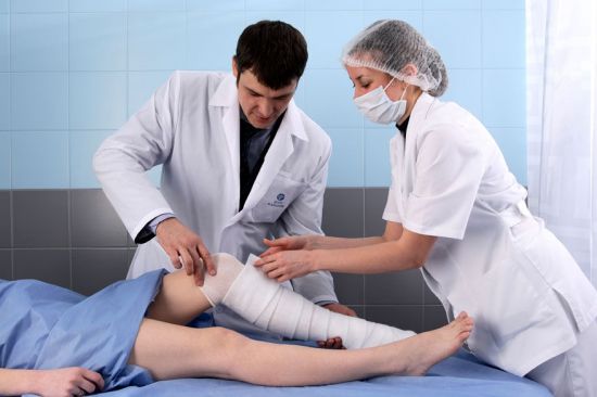 Травматолог гипсует ногу